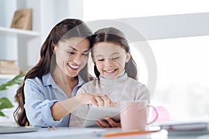 Happy beautiful woman reading a book with her daughter