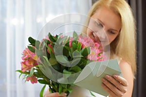 Happy beautiful woman reads a love letter. girl reads note from her beloved boyfriend.