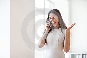 Happy beautiful woman screams in mobile phone