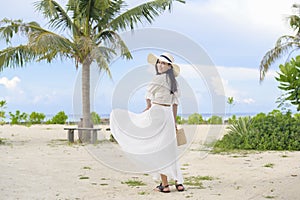 Happy beautiful woman in white dress enjoying and relaxing on the beach, Summer and holidays concept