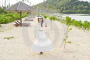 Happy beautiful woman in white dress enjoying and relaxing on the beach, Summer and holidays concept