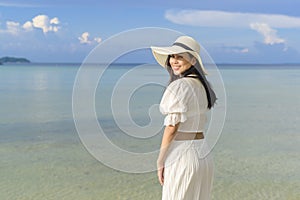 Happy beautiful woman in white dress enjoying and relaxing on the beach, Summer and holidays concept