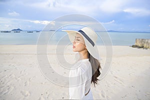 Happy beautiful woman in white dress enjoying and relaxing on the beach, Summer and holidays concept