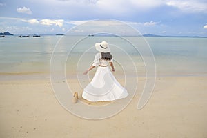 Happy beautiful woman in white dress enjoying and relaxing on the beach, Summer and holidays concept