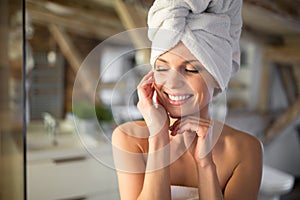 Happy beautiful woman wrapped in towels