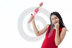 Happy beautiful young Asian black long hair woman in business casual red dress is smiling and holding red rose with feeling love