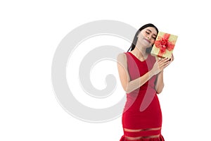 Happy beautiful young Asian woman in business red dress is smiling, holding gold presents, gifts boxes with red ribbon while she