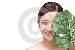 Happy beautiful young Asian woman with clean fresh skin and green leaves, Girl beauty face care.