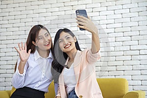 Happy beautiful young asian woman friendship selfie together , Happiness teenagers taking pictures selfie in living room