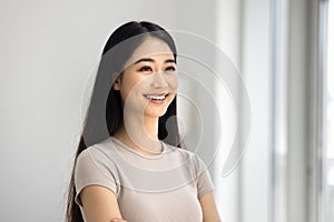 Happy beautiful young Asian woman home portrait with toothy smile