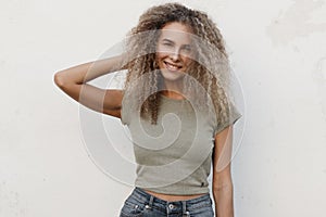 Happy beautiful young girl with curly hair with a smile