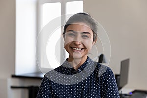Happy beautiful young Indian office employee woman head shot portrait