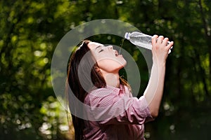 Happy beautiful young thirsty woman drinking water.