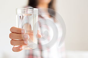 Happy beautiful young woman holding drinking water glass