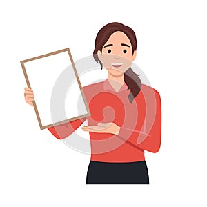 Happy beautiful young woman holding or showing a blank clipboard