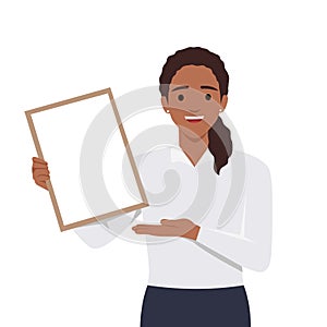 Happy beautiful young woman holding or showing a blank clipboard and showing hand to copy space