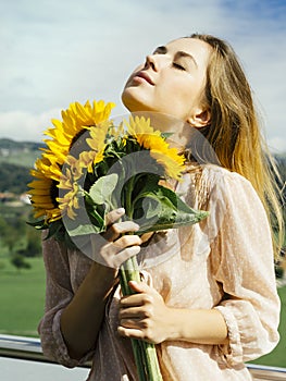 Happy beautiful young woman holding sunflowers