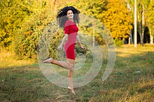 Happy beautiful young woman in red dress relax in summer park. Freedom concept