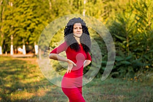 Happy beautiful young woman in red dress relax in summer park. Freedom concept