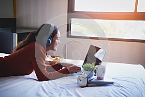 Happy beautiful young women working on bed using laptop computer at home. lifestyle and technology at home concept