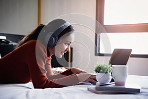 Happy beautiful young women working on bed using laptop computer at home. lifestyle and technology at home concept