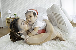 Happy Beauty mother Holding Cute Sweet Adorable Asian Baby wearing white dress