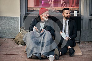 Happy beggar aeting with businessman on street