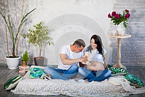 Happy beloved man and pregnant woman at home