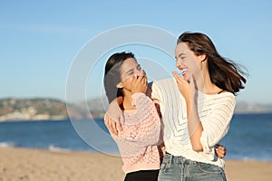 Happy best friends talking and laughing on the beach