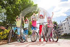 Happy bicycle riders standing in city park