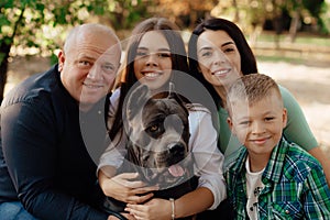 Happy big family with Cane Corso dog in park