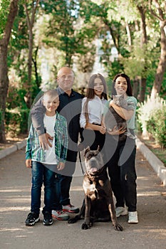 Happy big family with Cane Corso dog in park