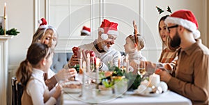 Happy big family with children exchanging gifts on Christmas morning at home