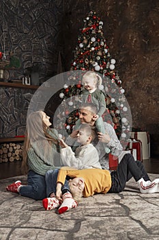 Happy big family at home. Mom dad and children near Christmas tree. Traditional xmas decorated living room. Xmas holiday