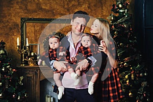 A happy big family with their children in the New Year& x27;s interior of the house by the fireplace next to the Christmas