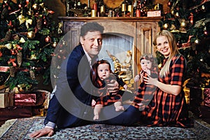 A happy big family with their children in the New Year& x27;s interior of the house by the fireplace next to the Christmas
