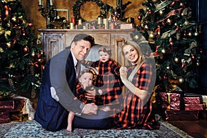 A happy big family with their children in the New Year& x27;s interior of the house by the fireplace next to the Christmas