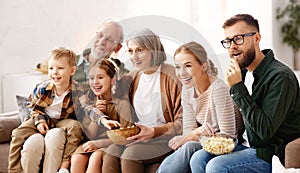 Happy big family watching TV and eating popcorn