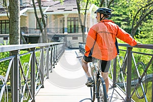 Happy biker ride on road in summer city park. Sport relax concept