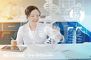 Happy biologist touching the DNA model and smiling