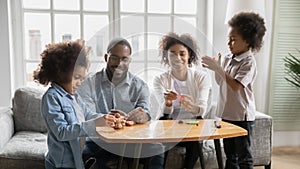 Happy biracial family with kids play with modeling clay