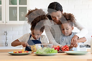 Happy biracial kids involved in preparing food with mum.