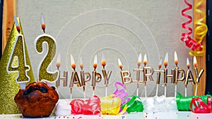 Happy birthday background with golden candles and decorations with candles burning number 42. Colorful festive card happy