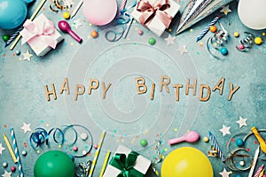 Happy birthday banner. Colorful holiday supplies on blue vintage table top view. Flat lay style.