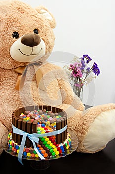 Happy birthday cake and big Teddy Bear. Festive tea party. Pinata Cake, a celebration cake with a hidden stash of sweets inside.