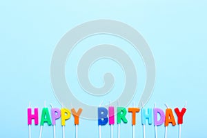 Happy birthday candles on blue background with copy space