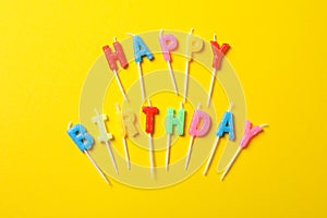 Happy Birthday candles on yellow background. Bright wallpaper