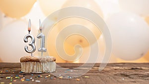 Happy birthday card with candle number 31 in a cupcake against the background of balloons. Copy space happy birthday for thirty