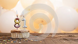 Happy birthday card with candle number 81 in a cupcake against the background of balloons. Copy space happy birthday for eighty
