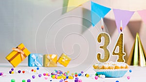 Happy birthday card from candles with the number 34, golden numbers from candles for congratulations on any holiday with beautiful
